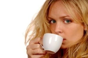 Young blonde woman drinking tea