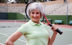 Senior woman posing with tennis racquet