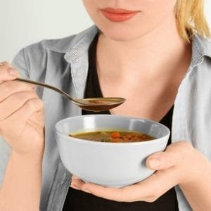The Satiating Diet Plan - Young woman eating soup