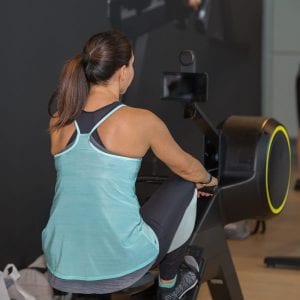 Back view of a woman working out on a rowing machine