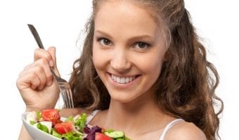 lose holiday weight - pretty young woman eating a salad