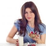 Finding the motivation to lose weight - Young smiling woman eating a healthy breakfast