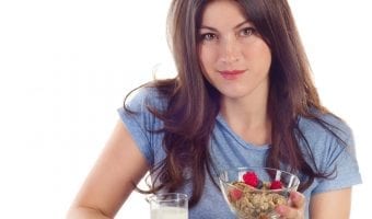 Finding the motivation to lose weight - Young smiling woman eating a healthy breakfast