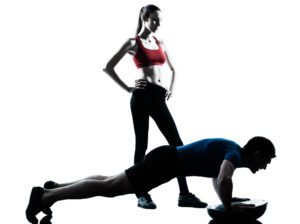 Man doing Incline Push-Ups watched by ffemale itness trainer