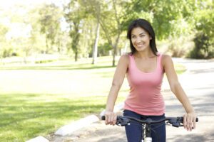 Young Woman Riding Bike In Park
