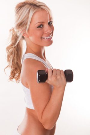Close-up of a young blonde woman lifting a dumbbell