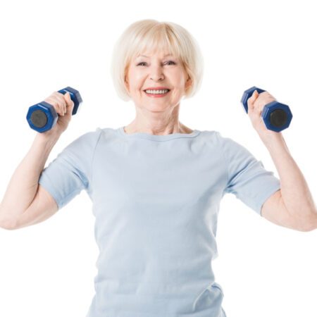 Smiling, senior woman lifting dumbbells