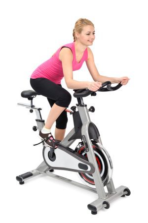 Young blonde woman exercising on an indoor bike 